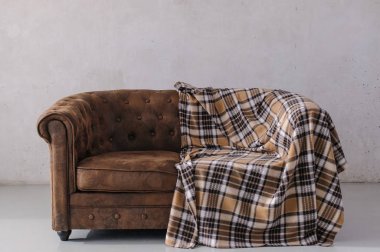 kahverengi deri kanepe gri duvara karşı