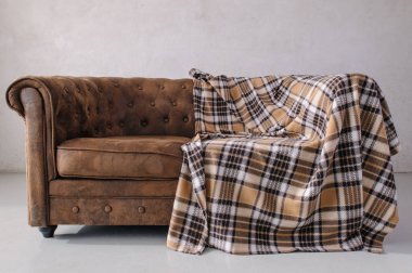 kahverengi deri kanepe gri duvara karşı