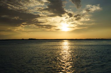 günbatımı üzerinde su ve bulutlar