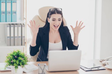 Portrait of glad cheerful yelling financier gesturing with hands looking at screen of laptop celebrating a great triumph big effective results having fun sitting in modern workstation clipart