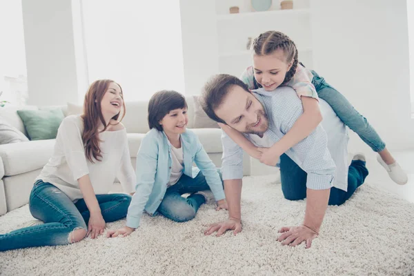 爸爸的肖像站在膝上背着女儿妈妈和儿子坐在地板上笑着玩游戏 自由时间白日梦家庭生活方式养育关心概念 — 图库照片