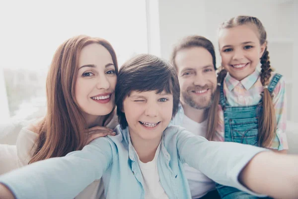 Self portrait of cheerful joyful four people shooting selfie on front camera cool boy winking with one eye enjoying free time together having good mood. Domestic lifestyle concept