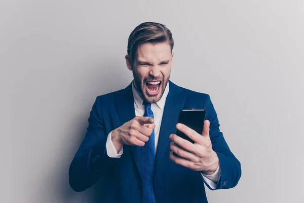 Anger mobilephone mad emotion expressing partner internet people person concept. Portrait of disappointed mad confused with open mouth financier with phone in hand isolated on gray background