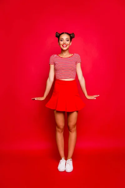 幸せな若い女の子のフルレングスの垂直縦赤スカートの着用し ストライプ シャツ スタンド直立見て赤の背景に分離カメラ — ストック写真