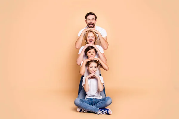 Young adorable attractive beautiful smiling family, bearded father, blonde mother, boy and girl wearing blue jeans and white T-shirts, standing in odrer of hierarchy, holding hands on each other — Stock Image Young Adorable Attractive Beautiful Smiling Family Bearded Father Blonde Mother Royalty Free Stock Images