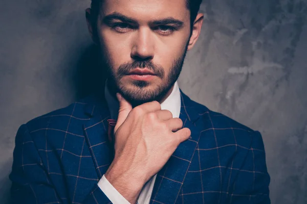 Close up studio photo portrait of handsome attractive confident sure serious scarring brunet keeping palm near chin clothed in checkered blazer isolated on gray background
