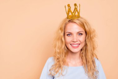 Portrait of attractive beautiful curly-haired cheerful blonde caucasian young girl wearing golden crown on head. Copy space. Isolated over grey background clipart