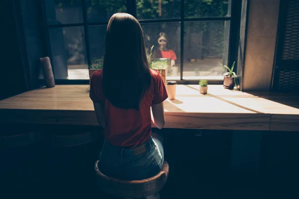 背面から見る魅力的なブルネットの少女カフェの窓際の席に座っている長い髪 — ストック写真
