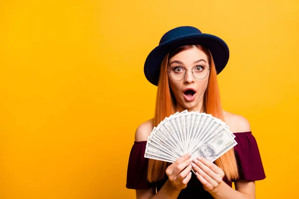 Wondered young girl in hat looks at camera with lot of money in — Stock Photo, Image