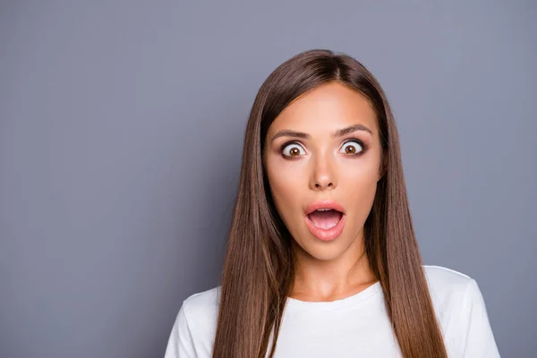 Primer plano retrato de cabello castaño hermosa dama joven asombrada sobre fondo gris, aislado, espacio de copia —  Fotos de Stock