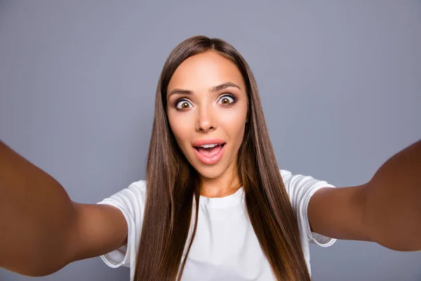 ¿Me puedes aquí Selfie de chica sorprendida disparando selfie en la cámara frontal con dos manos aisladas sobre fondo gris — Foto de Stock