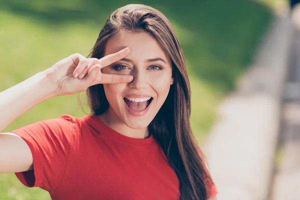 Ritratto ravvicinato di una ragazza allegra in una t-shirt rossa che mostra — Foto Stock