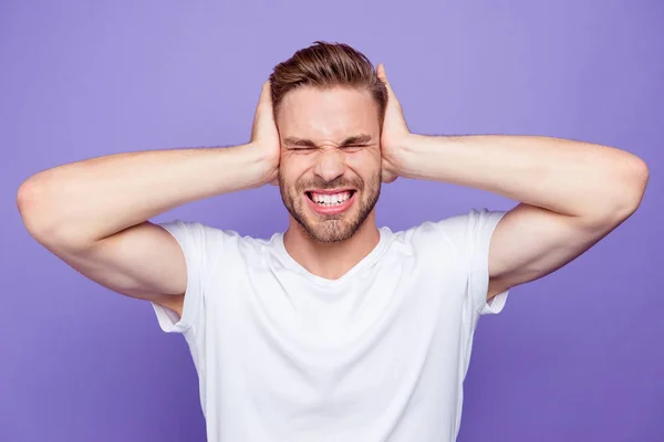 Portrait of handsome bearded crazy guy covering ears with palms, — Stock Photo, Image