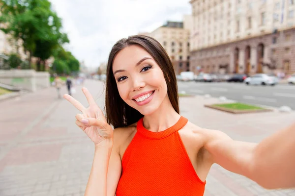 Hezká mladá žena, takže selfie na smartphone a ukazuje dva f — Stock fotografie