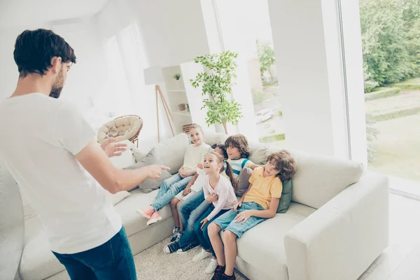 Nieuwsgierige kinderen kijken naar de vader die verhalen gesticulat vertelt — Stockfoto