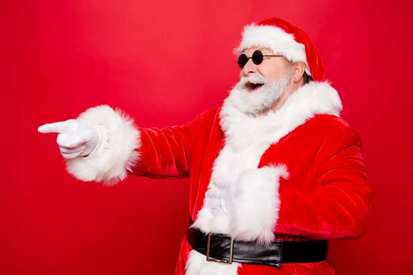 冬天的圣诞节 侧面视图幽默时尚风格成熟圣诞老人在眼镜白色胡子索引指针手指一边使喜气洋洋的牙齿微笑孤立的红色背景 — 图库照片