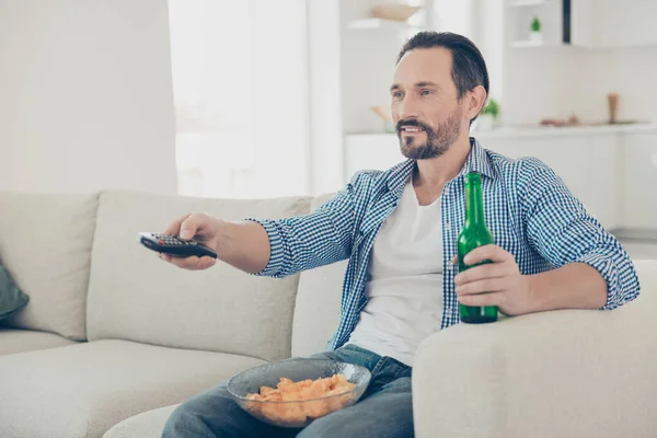 Halvveis rolig, selvsikker, glad mann sitter på den koselige sofaen insi – stockfoto