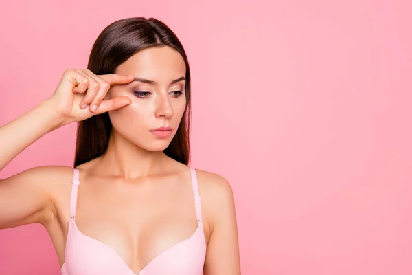 Close up portrait of serious brunette gorgeous problem facial skin her she feminine girl ready to make plastic rejuvenation of eyes wearing pale pink bra isolated on rose background