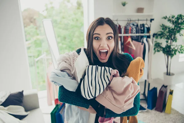 Portrait of nice attractive pretty funny shocked girl student holding pile many different things in hands screaming loudly in light white interior room — Stock Photo, Image