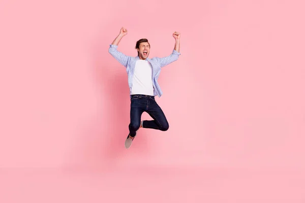 Full längd kropp storlek foto av hoppning hög crazy heja han hans honom stilig glad skrek högt upp armarna bär casual jeans rutig pläd skjorta isolerade på rosa bakgrund — Stockfoto