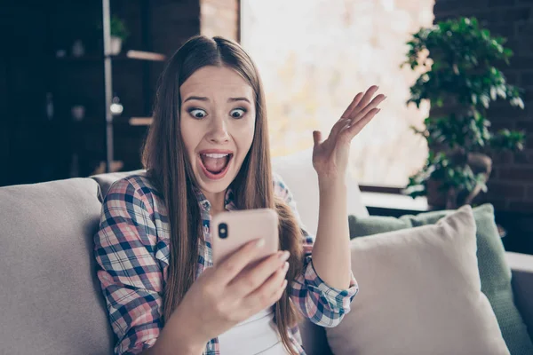 Closeup photo portrait of terrified scared frightened with big staring eyes she her lady in casual plaid checkered outfit shirt raising hands up see watch telephone screen