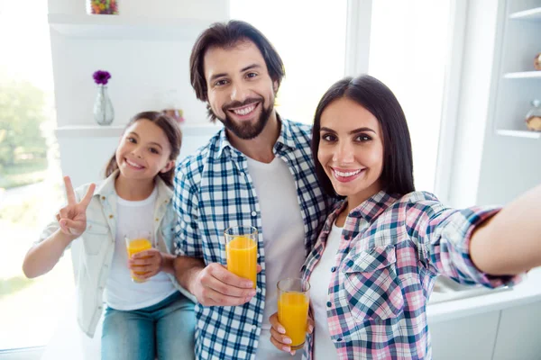 Self-portrait of nice cute sweet lovely attractive trendy cheerful positive people mom dad useful healthy fresh citrus squeezed juice c-vitamin showing v-sign in light white modern interior indoors — Stock Photo, Image