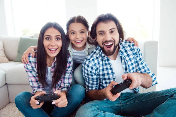 Portret van leuke schattige mooie aantrekkelijke vrolijke positieve grappige mensen moeder vader bijwonen wedstrijd competitie zittend op de vloer tapijt vrije tijd in lichte witte moderne interieur binnenshuis — Stockfoto