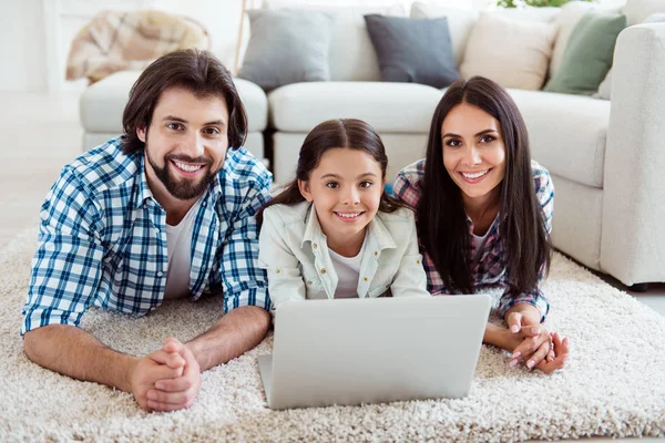 Portrait of nice cute adorable lovely sweet attractive cheerful cheery friendly people mom dad lying on floor carpet free time using wi-fi in light white modern interior indoors — Stock Photo, Image