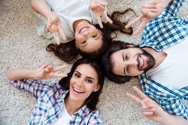 Nahaufnahme oben über dem Hochwinkel Ansicht Porträt von netten netten schönen attraktiven fröhlichen fröhlichen Menschen Mama Papa liegt auf hellem Teppich zeigt V-Zeichen Spaß haben Hippie drinnen — Stockfoto