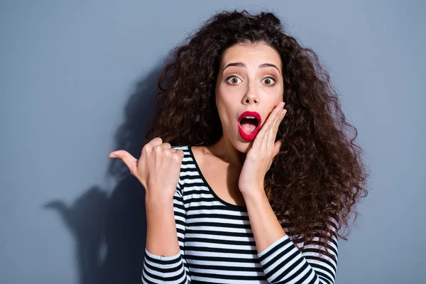 Primer plano foto retrato de loco extático encantador bonito con labios brillantes pelo marrón ojos grandes atractivo adolescente demostrando copyspace al lado cerca hombro aislado fondo gris —  Fotos de Stock