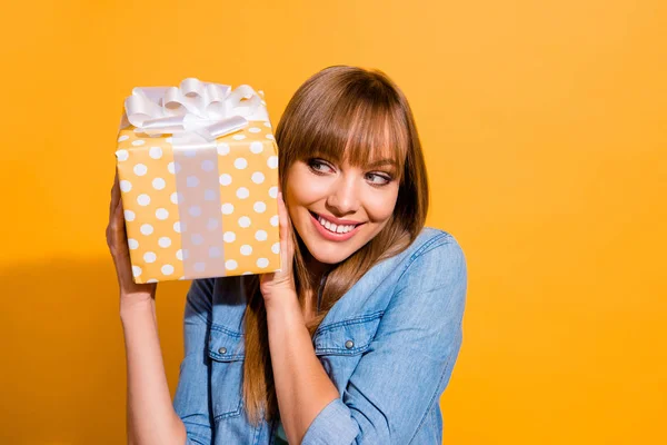 De cerca retrato de hermosa atractiva ella su señora sosteniendo gran caja de regalo en las manos alegres listo para desempacar con vaqueros casual camisa de mezclilla ropa aislada sobre fondo amarillo — Foto de Stock