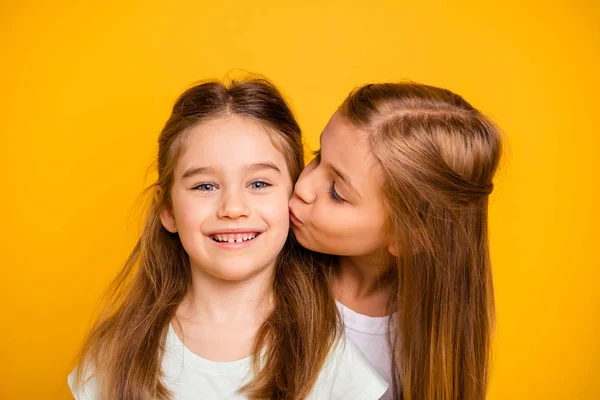 Detail portrét dvou pěkné rozkošný atraktivní krásné sladké veselá veselý pozitivní dívčí dívek baví líbání péče podpora důvěry izolovaný jasný a intenzivní lesk žluté pozadí — Stock fotografie