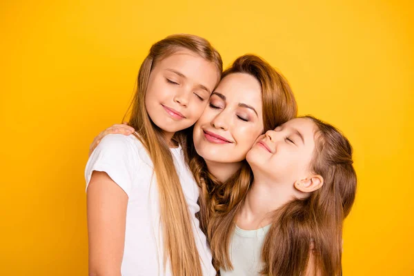 Close-up portrait of three nice cute adorable sweet tender attractive cheerful caucasian people cuddling mum mommy closed eyes isolated over bright vivid shine yellow background — Stock Photo, Image