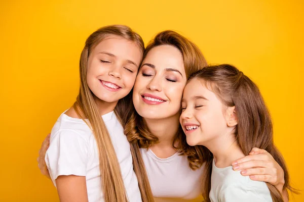 Close-up portrait of three nice cute winsome lovable lovely sweet tender attractive cheerful caucasian people cuddling mum mommy closed eyes isolated over bright vivid shine yellow background — Stock Photo, Image