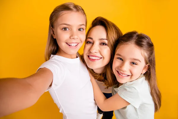 Self-portrait of three nice lovely attractive winsome dreamy cheerful cheery positive people cuddling mommy mum isolated over bright vivid shine yellow background — Stock Photo, Image