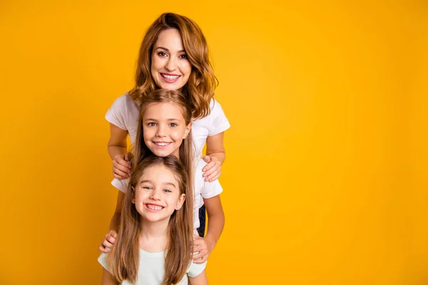 Portrait of three nice cute adorable lovely lovable attractive cheerful positive funny people standing in order of height having fun isolated over bright vivid shine yellow background — Stock Photo, Image