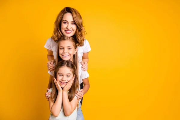 Porträtt av tre trevliga Söt härlig attraktiva winsome söta glada positiva roliga blonda människor står i ordning av höjd fritid isolerade över ljusa levande glans gul bakgrund — Stockfoto