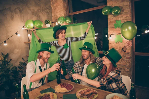 National irish traditional culture holiday party drinking ale brew green symbol flag raised up balloons lights decorated house four-leaves leprechaun caps drunk gathering big company