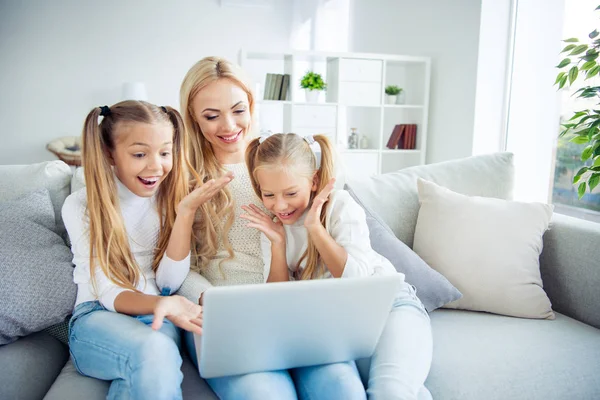 Portrait of three nice-looking cute lovely attractive cheerful cheery positive people pre-teen girls mom sitting on divan making video call w-fi in light white interior room indoors — Stock Photo, Image