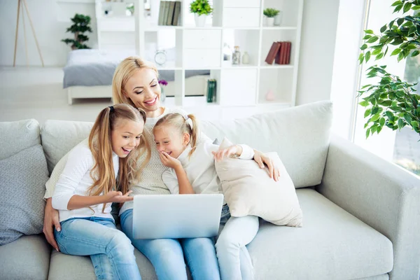 Three nice cute lovely lovable attractive charming cheerful positive people pre-teen girls mom mommy sitting on divan making videocall relatives in light white interior room indoors — Stock Photo, Image