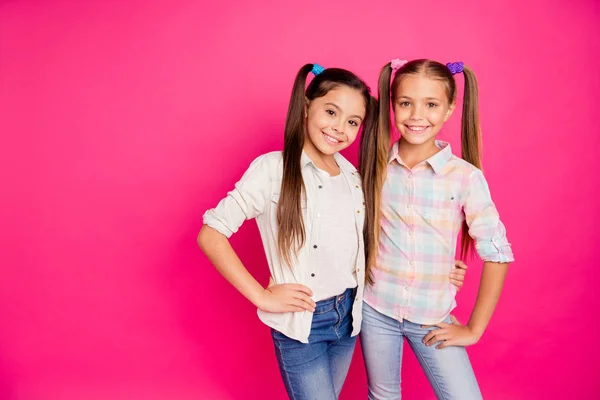 Nära upp foto två små små ålder flickor bästa vänner kompisar kramas toothy leende sött bär casual jeans denim rutig pläd skjortor isolerade ros levande pulserande ljus bakgrund — Stockfoto