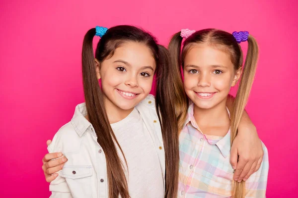 De cerca la foto de dos pequeños de poca edad que sus chicas abrazando amigos como fotografiar alegremente sonriendo con vaqueros vaqueros casuales camisas a cuadros aislados rosa vibrante brillante fondo vivo —  Fotos de Stock