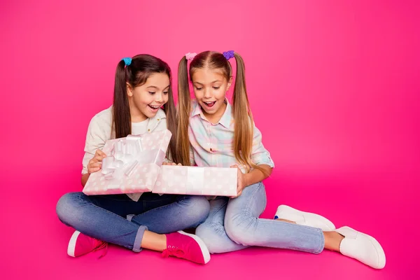 特写照片两个小年龄她的女孩手抱着大礼品盒最好的朋友坐在地板上穿休闲牛仔裤牛仔格子格子衬衫孤立玫瑰充满活力生动的背景 — 图库照片