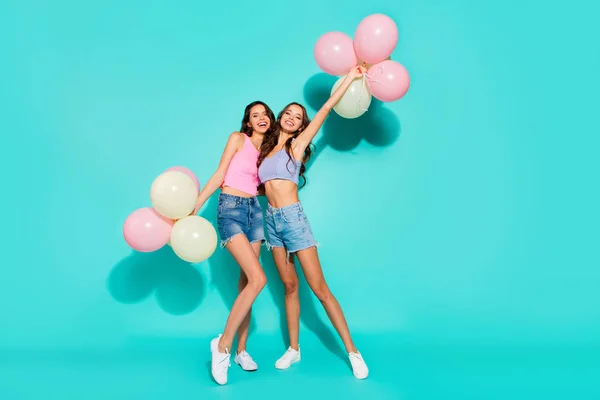 Longitud completa tamaño del cuerpo foto divertido hermoso increíble dos ella sus damas color globos manos brazos humor playa partido con pantalones vaqueros brillantes pantalones vaqueros camisetas de tanque aislado verde azulado brillante fondo vivo —  Fotos de Stock