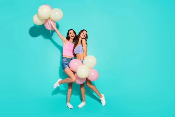 Longitud completa tamaño del cuerpo foto divertido hermoso increíble dos ella sus damas globos de colores manos brazos levantados piernas delgadas con pantalones vaqueros brillantes pantalones cortos tanque tops aislados verde azulado brillante fondo vivo —  Fotos de Stock