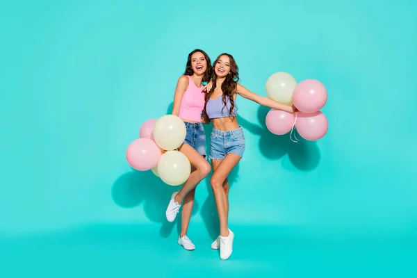 Full length body size photo beautiful amazing two she her ladies colored balloons hands festive gorgeous hips wearing pink blue jeans denim shorts tank tops isolated teal bright background — стоковое фото