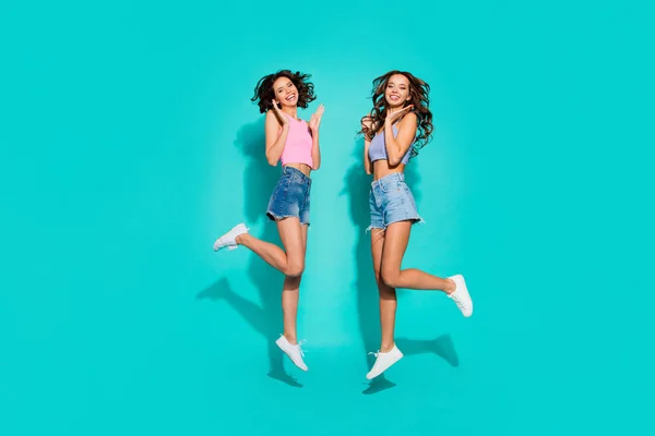 Full length body size side profile photo jumping beautiful funky wavy she her ladies hands raised great fortune wearing shiny jeans denim shorts tank tops isolated teal bright vivid background — стоковое фото