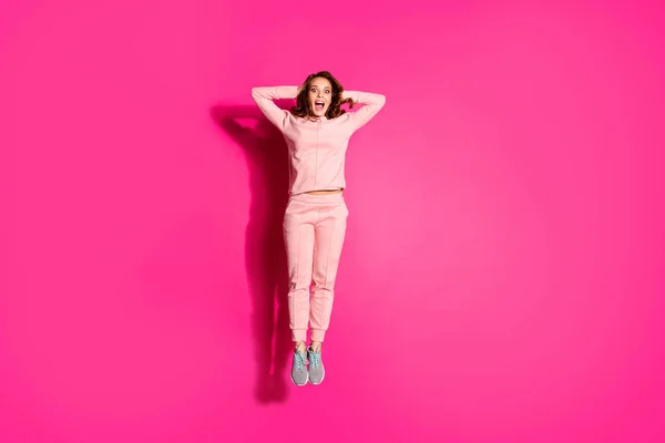 Ganzkörpergröße Foto springen hoch erstaunlich sie ihre Dame Hände Arme hinter dem Kopf unglaublichen Erfolg einkaufen tragen lässig rosa Kostüm Anzug Pullover-Outfit isoliert lebendige rosa Hintergrund — Stockfoto