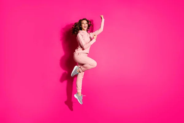 Full length body size photo funky jump high amazing she her lady hands arms fists raised great flexibility wearing casual pink costume suit pullover outfit isolated bright vibrant rose background