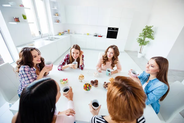 Gros plan photo belle elle ses dames souriant boire boisson chaude meilleurs amis assis autour grande table cuisine lumineuse écouter rumeurs nouvelles secrets filles jour nuit vacances à l'intérieur — Photo